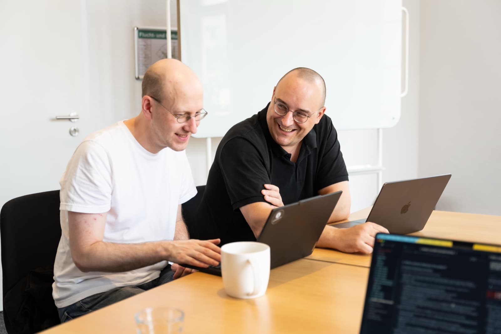 Zwei Entwickler arbeiten gemeinsam am Laptop