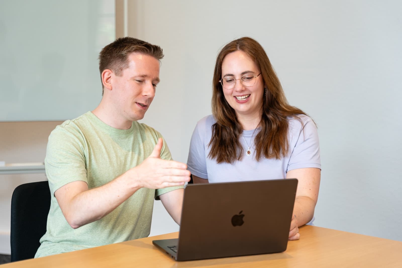 Zwei Teammitglieder arbeiten gemeinsam am Laptop